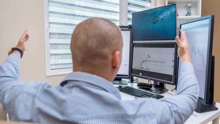 A stock trader celebrating while monitoring multiple screens with financial charts, representing record ETF launch activity in 2026