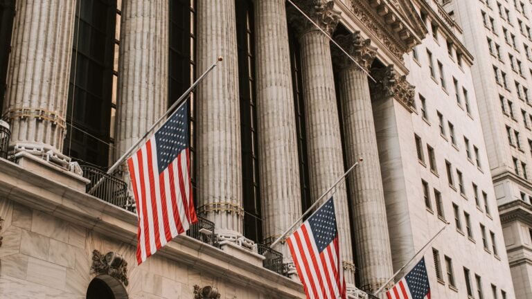 Iconic New York Stock Exchange with American flags on Wall Street, representing stocks rebounding sharply after the Fed's rate hike